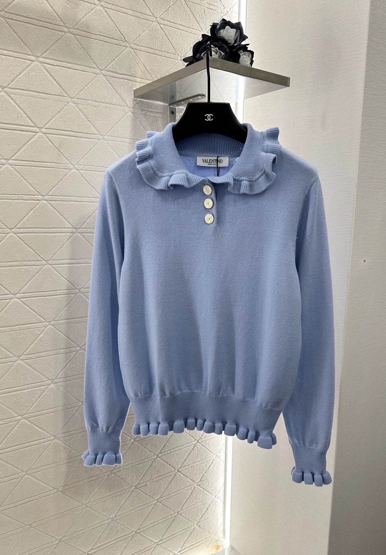 V 25 Long-sleeved knitted top with ruffled collar.