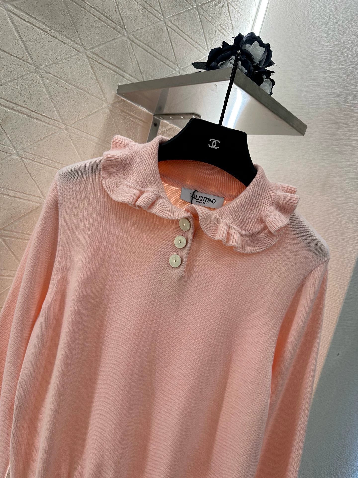 V 25 Long-sleeved knitted top with ruffled collar.
