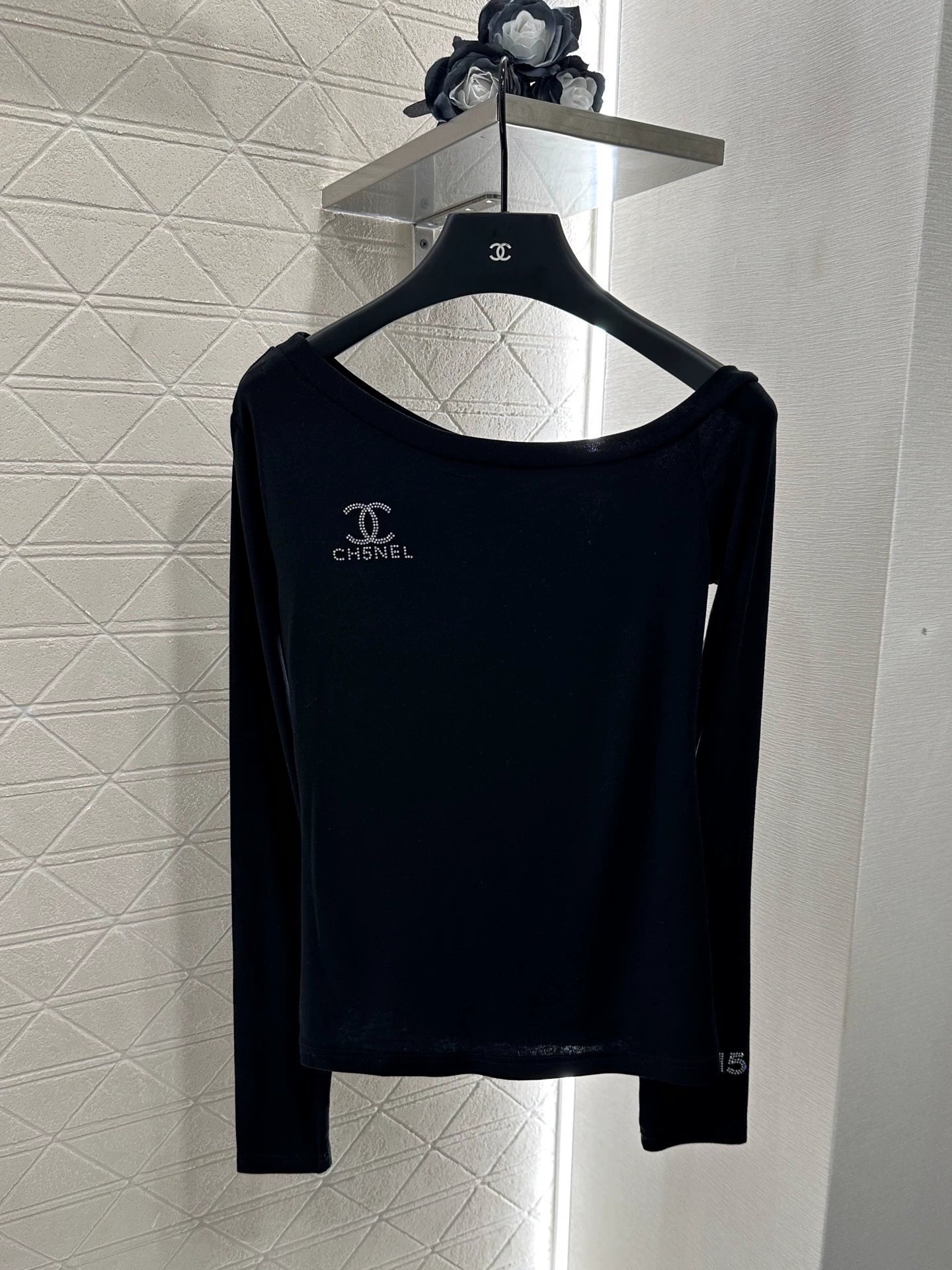 C 25 Slim-fitting, rhinestone-embellished, off-shoulder top.