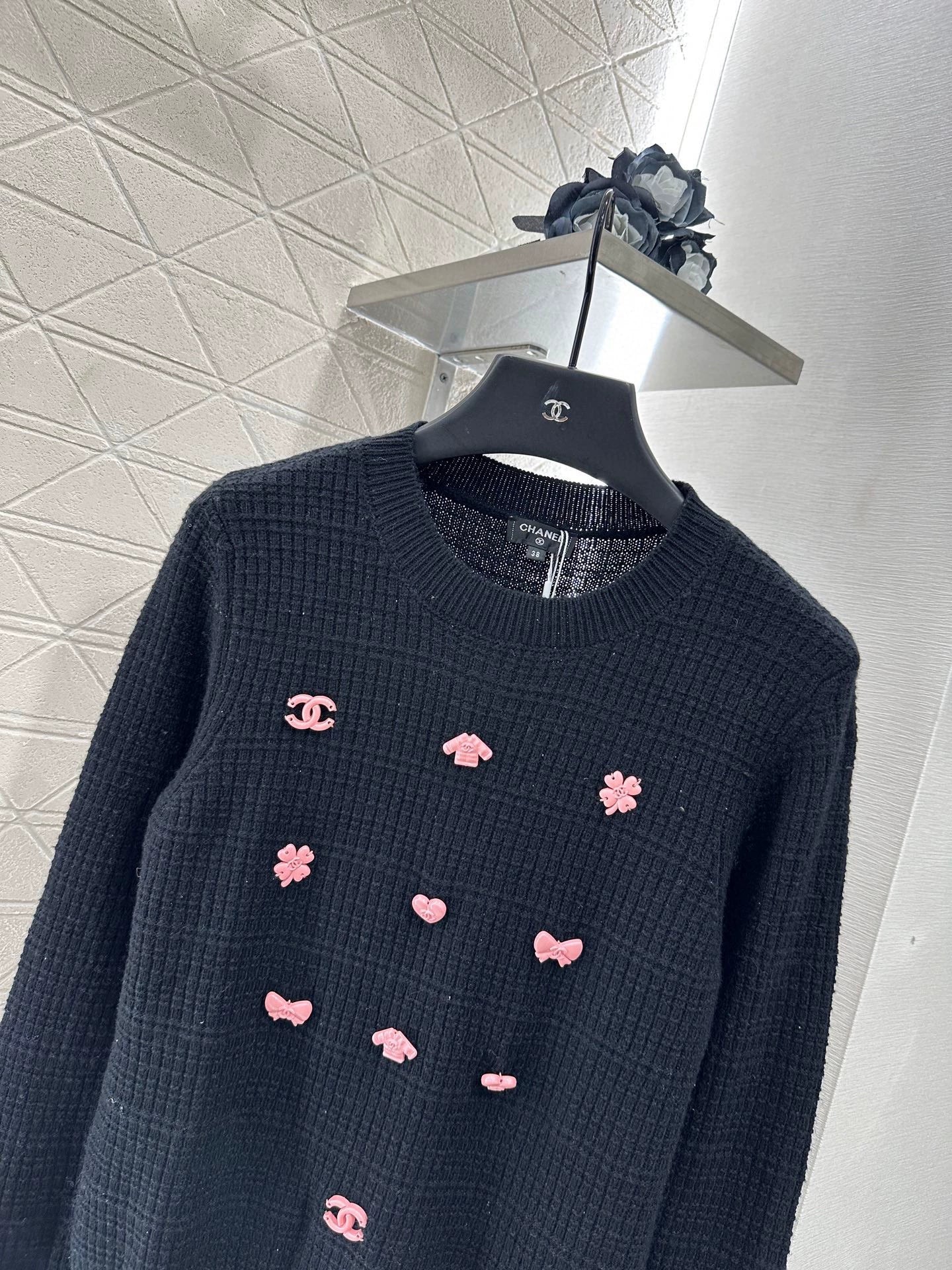 C 25 A simple logo sweater with a chain detail at the back waist.