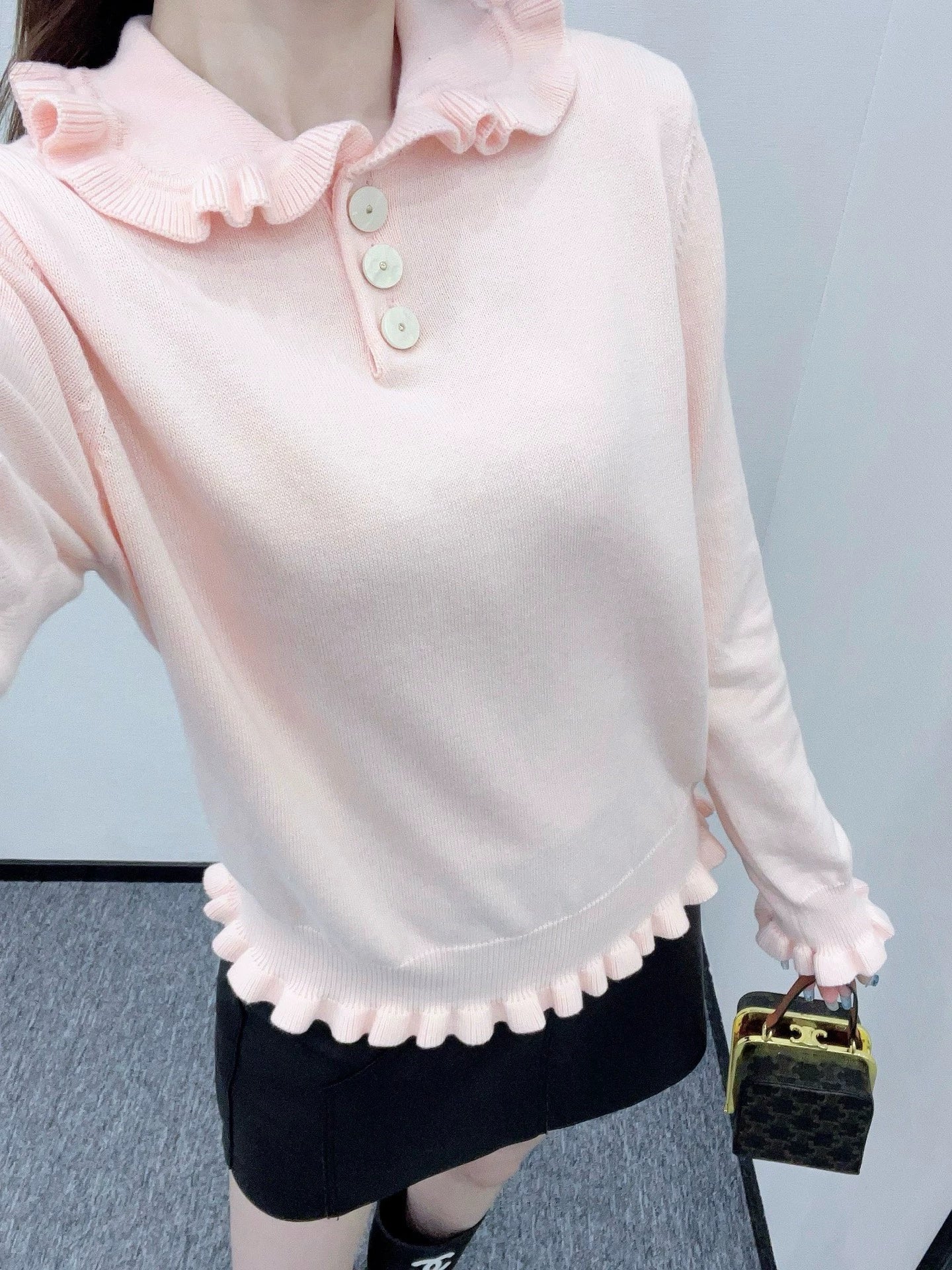 V 25 Long-sleeved knitted top with ruffled collar.