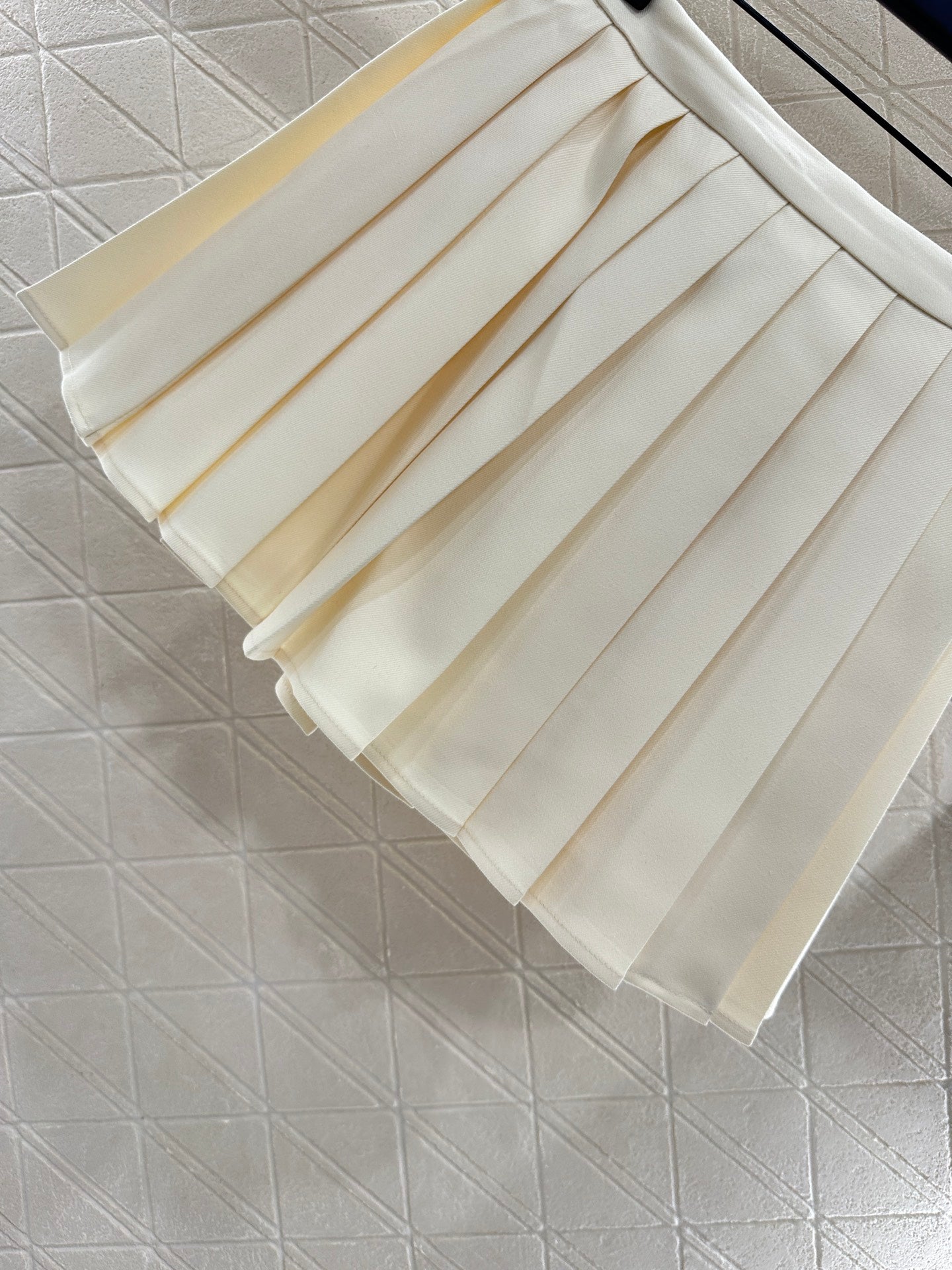 L 25 High-waisted pleated skirt with one side buckle