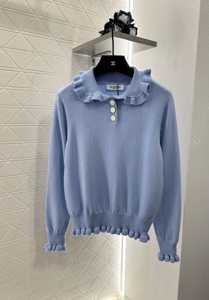 V 25 Long-sleeved knitted top with ruffled collar.