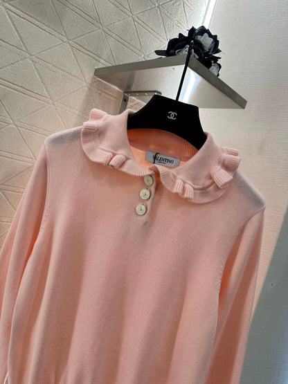V 25 Long-sleeved knitted top with ruffled collar.