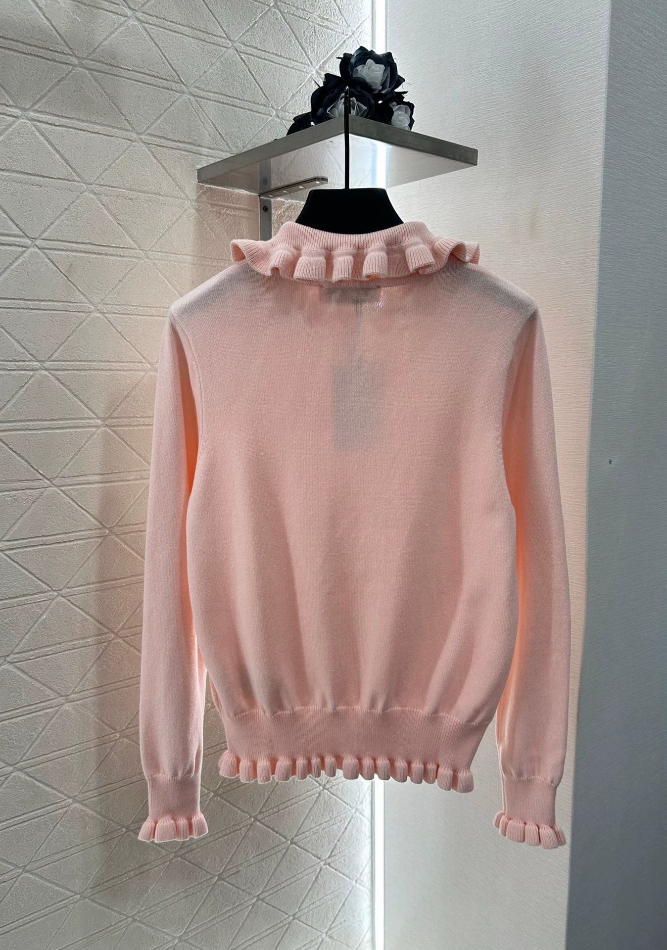 V 25 Long-sleeved knitted top with ruffled collar.