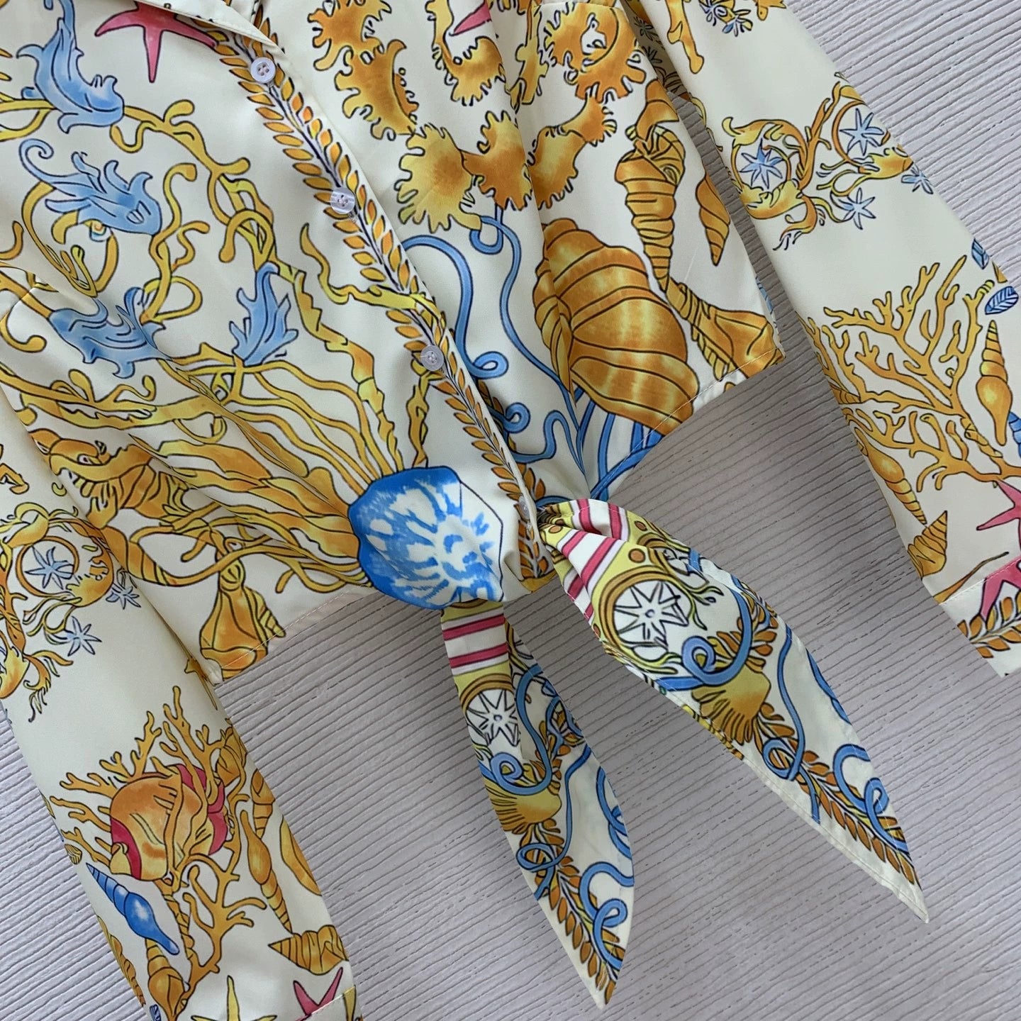 Ve New 25-inch starfish and conch shell print two-piece suit with a stylish holiday vibe.