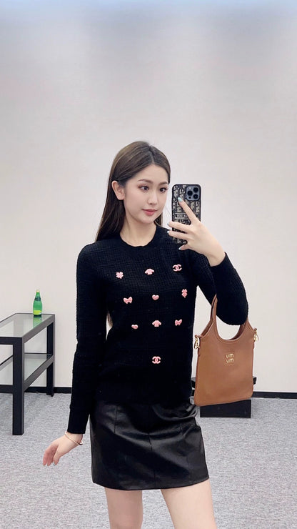 C 25 Un pull simple avec un logo et un détail de chaîne à la taille arrière. 