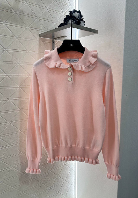 V 25 Long-sleeved knitted top with ruffled collar.