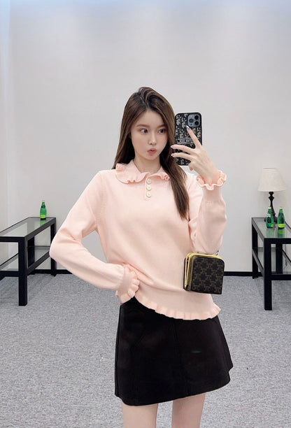 V 25 Long-sleeved knitted top with ruffled collar.
