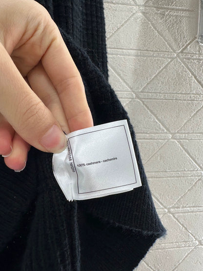 C 25 Un pull simple avec un logo et un détail de chaîne à la taille arrière. 