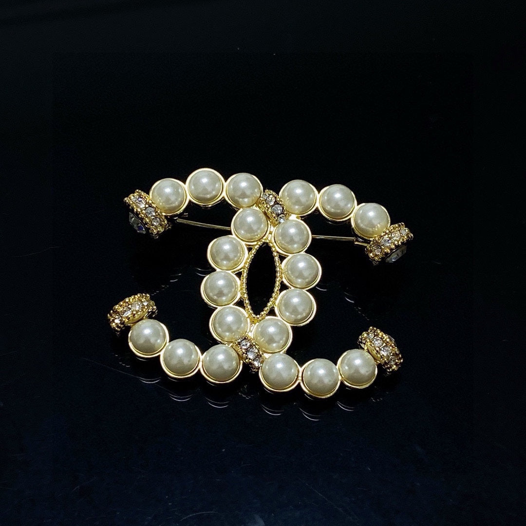 C 25 Pearl logo brooch
