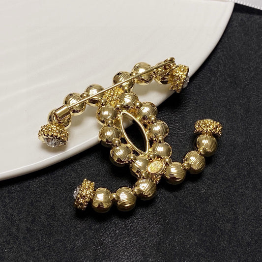 C 25 Pearl logo brooch